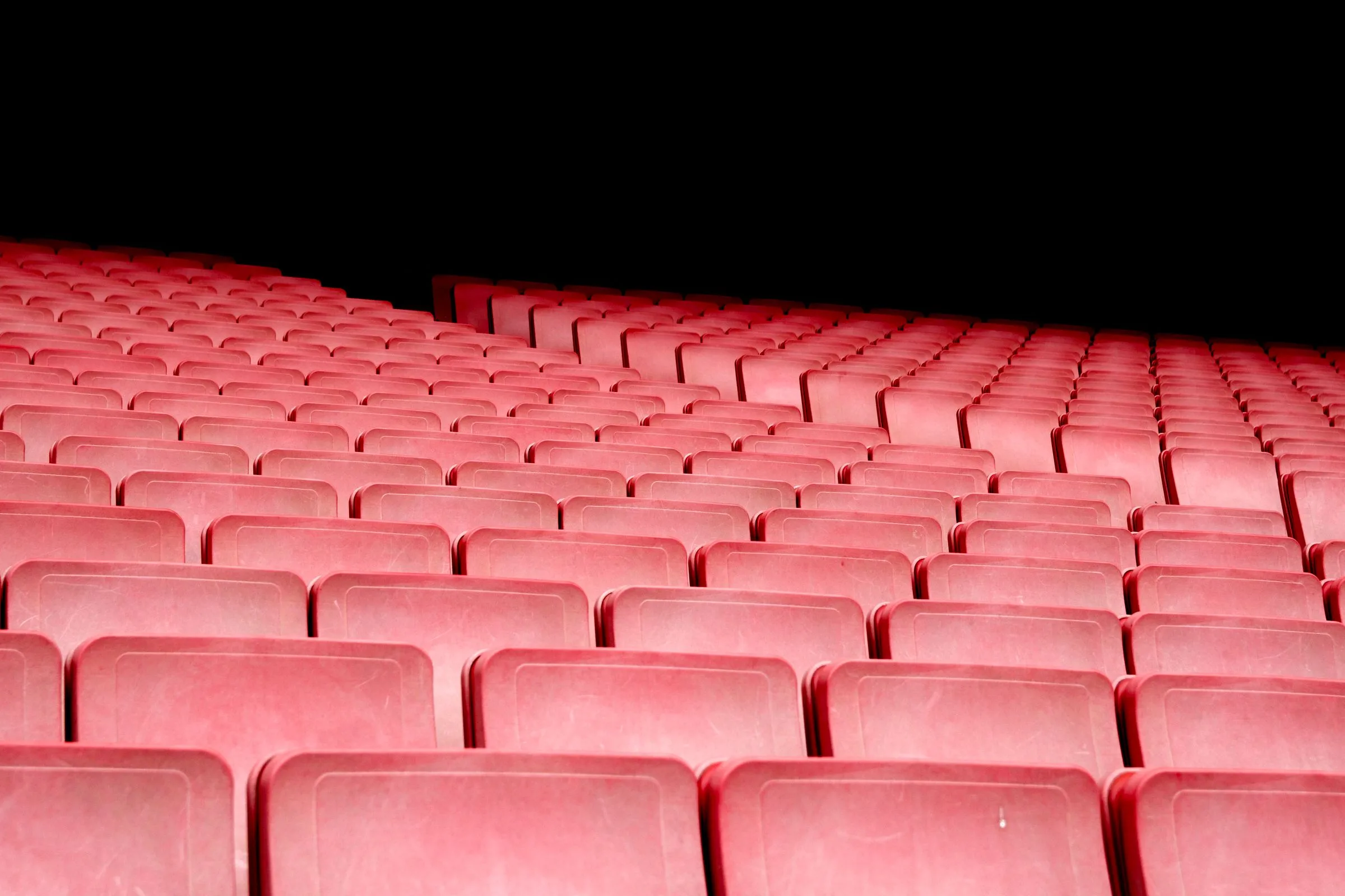 Rows of empty auditorium seats climbing away from the stage